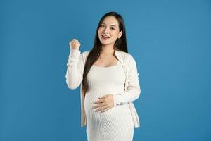 portrait de Enceinte asiatique femme, isolé sur bleu Contexte photo