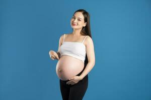 portrait de Enceinte asiatique femme, isolé sur bleu Contexte photo