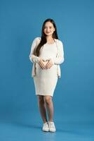 portrait de Enceinte asiatique femme, isolé sur bleu Contexte photo