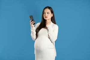 portrait de Enceinte asiatique femme, isolé sur bleu Contexte photo