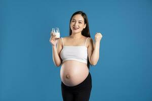 portrait de Enceinte asiatique femme, isolé sur bleu Contexte photo