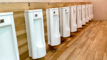 vue en perspective de l'urinoir pour hommes avec système de nettoyage automatique dans les toilettes publiques du centre commercial. photo