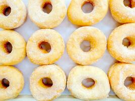 Haut vue et surgir beaucoup de Donut avec sucre sur boulangerie papier Contexte. Donut est le un causes maladie de coronaire artère maladie et obésité. photo