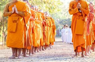 bouddhiste moine est permanent avec le sien mains plié dans le forme de une lotus à effectuer certains religieux rituel, uniforme bouddhiste moine, bouddhiste moine prier photo