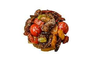 chaud salade avec veau, tomates, poivrons, courgette, sésame, sel, épices et herbes photo