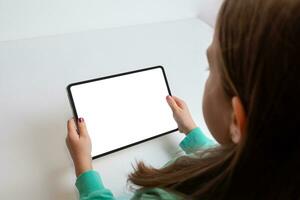 fille en train de regarder une film sur une tablette dans une horizontal position à sa travail bureau. isolé écran pour multimédia promotion photo