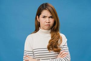 jeune femme asiatique avec une expression négative, criant excité, pleurant émotionnellement en colère dans des vêtements décontractés et regardant la caméra isolée sur fond bleu. heureuse adorable femme heureuse se réjouit du succès. photo