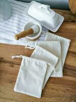 blanc coton Sacs et ustensiles sur une en bois tableau. en tissu sac maquette photo