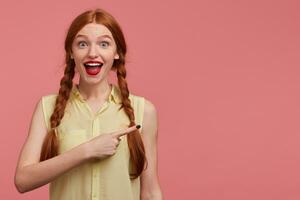 intérieur portrait de Jeune gingembre femelle avec taches de rousseur posant plus de rose Contexte photo