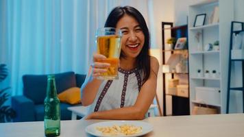 jeune femme asiatique buvant de la bière s'amusant bonne nuit fête du nouvel an célébration en ligne par appel vidéo par téléphone à la maison la nuit. distance sociale, quarantaine pour le coronavirus. point de vue ou pov