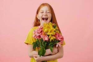 photo de menue en riant taches de rousseur roux fille avec deux queues, avec fermé yeux largement souriant et regards mignon, détient bouquet, porte dans Jaune T-shirt, des stands plus de rose Contexte.