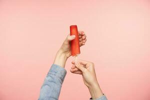 horizontal coup de Jeune féminin mains avec nu manucure posant plus de rose Contexte avec crème glacée sur bâton avec rouge glaçage. nourriture la photographie concept photo