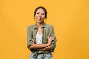 portrait d'une jeune femme asiatique avec une expression positive, les bras croisés, un large sourire, vêtue de vêtements décontractés et regardant la caméra sur fond jaune. heureuse adorable femme heureuse se réjouit du succès.