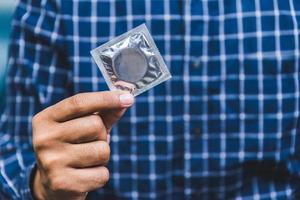 main masculine tenant le préservatif. concept de sexe sans risque.