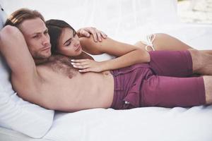 beau jeune couple en maillot de bain sur la plage contre un sourire de sable et un câlin. photo