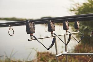 cannes à pêche à la carpe debout sur des trépieds spéciaux. bobines coûteuses et un système radio de crochet