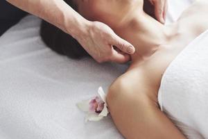 gros plan d'une jeune femme reçoit un massage au salon de beauté. procédures pour la peau et le corps. photo