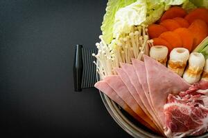 soupe noire sukiyaki ou shabu hot pot avec de la viande crue et des légumes photo