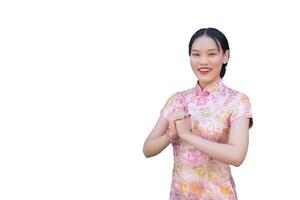 magnifique asiatique femme avec rose longue cheongsam robe dans chinois Nouveau année thème tandis que elle spectacles sa main comme chinois salutation tandis que isolé blanc Contexte. photo