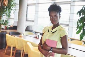 femme d'affaires afro-américaine se tient avec un dossier dans ses mains photo