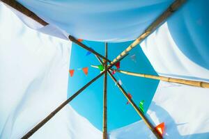 coloré petit drapeaux dans le ciel. agitant petit coloré drapeaux pendaison sur le corde pour vacances contre bleu ciel. photo