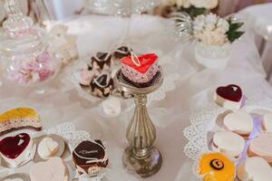 de fête dessert table avec bonbons. mariage bonbons bar, divers Gâteaux, des chocolats sur des stands. photo