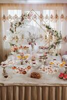 de fête dessert table avec bonbons. mariage bonbons bar, divers Gâteaux, des chocolats sur des stands. photo