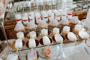 de fête dessert table avec bonbons. mariage bonbons bar, divers Gâteaux, des chocolats sur des stands. photo