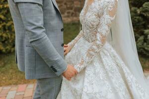 le la mariée et jeune marié sont tendrement en portant mains fermer photo