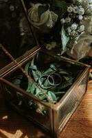 original mariage anneaux dans or et verre boîte sur en bois sol dans agréable lumière photo