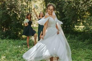 une la mariée fête sa mariage avec copains en plein air après le la cérémonie photo