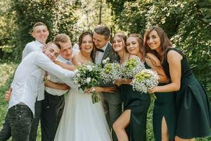 le la mariée et jeune marié célébrer leur mariage avec copains en plein air après le la cérémonie photo