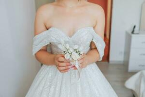 le du marié boutonnière est arrangé de Rose fleurs dans le mains de le la mariée avec une français manucure dans le magnifique Naturel lumière de le fenêtre photo