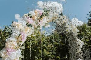 mariage la cérémonie dans le cour. rond cambre de fleurs et branches sur une vert Contexte. mariage thème. vacances concept photo