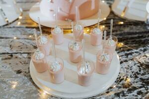 une délicieux mariage. blanc gâteau décoré avec fleurs. bonbons bar pour une banquet. fête concept. à la mode desserts. table avec bonbons, des sucreries. des fruits photo