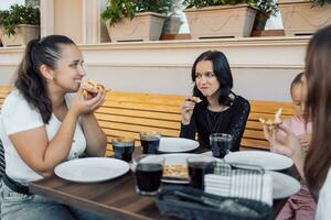 une groupe de adolescents dans une café en mangeant pizza, bavardage et relaxant photo