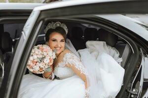 portrait de une content et souriant la mariée dans le voiture fenêtre à la recherche à le caméra photo