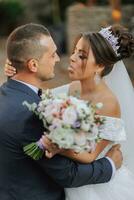 portrait de content mariage couple, la mariée et jeune marié dans l'automne forêt, parc posant près pierre escaliers. une homme dans une costume, une fille dans une mariage robe. jeune marié baisers le sien petite amie. photo de au dessus