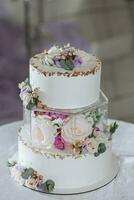 une délicieux mariage. à trois niveaux gâteau décoré avec fleurs. bonbons bar pour une banquet. fête concept. à la mode desserts. table avec bonbons, des sucreries. des fruits photo