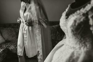 le la mariée dans Matin soie dans sa chambre. le la mariée est en train de préparer pour sa mariage. noir et blanc photo
