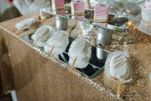 une sucré table à une mariage. table avec Gâteaux et bonbons à le festival. anniversaire bonbons photo