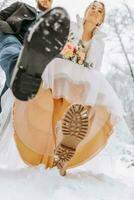 jeune marié et la mariée dans cuir bottes à une hiver mariage. fermer de la mariée et jeune marié chaussures. mariage dans l'hiver. photo