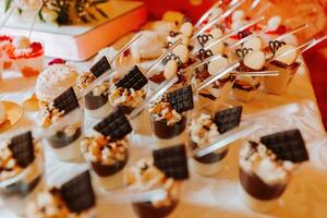 une sucré table à une mariage. table avec Gâteaux et bonbons à le festival. anniversaire bonbons photo