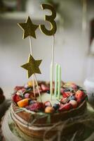 anniversaire gâteau avec baies et étoiles sur une en bois table dans le cuisine photo