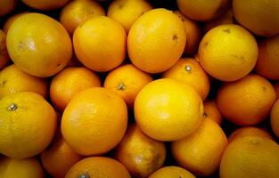 proche en haut de une groupe de mandarines sur afficher à une marché photo