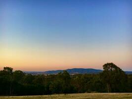 le coucher du soleil dans le australien arrière-pays, avec le montagnes dans le Contexte photo