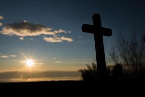 silhouette de croix catholique et lever de soleil photo