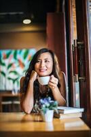 portrait, femme asiatique, sourire, se détendre, dans, café-restaurant, café photo