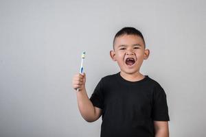 petit garçon se brosser les dents en photo studio