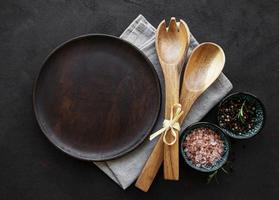 assiette en bois vide sur fond noir photo